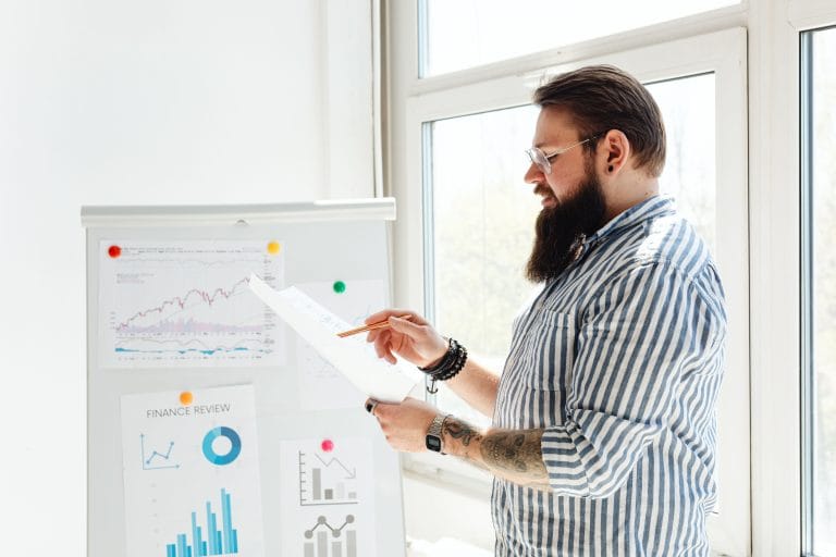 Dirigeant de PME consultant un tableau de bord financier pour l'optimisation de sa gestion de trésorerie.