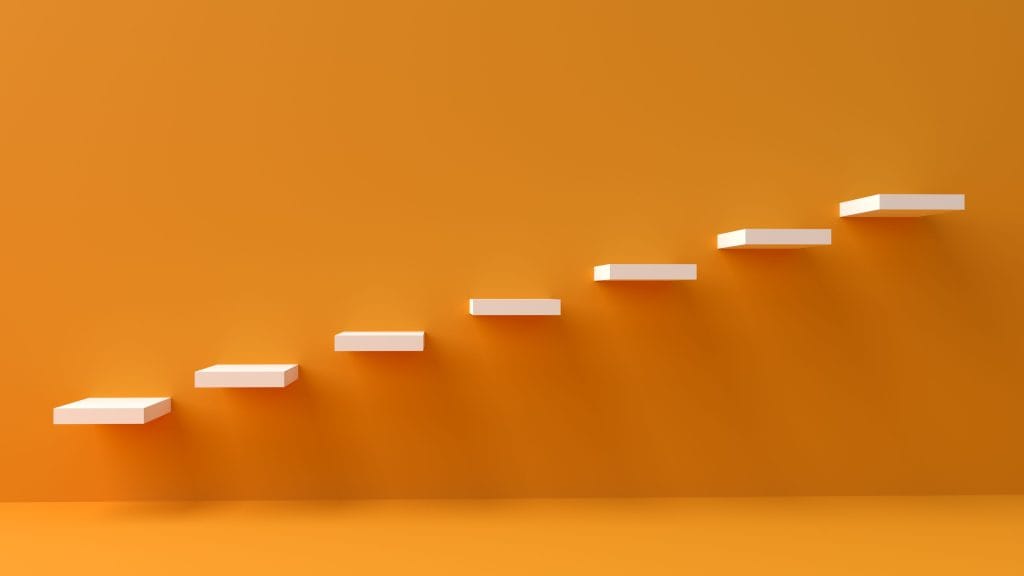 Escalier moderne sur fond orange symbolisant la progression et les etapes de croissance d une PME