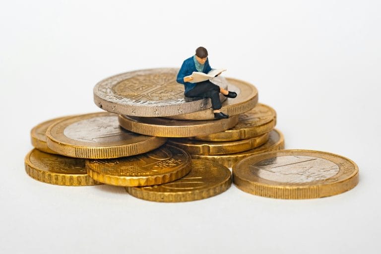 Investisseur analysant ses placements assis sur des pièces de monnaie – concept d’investissement dans les PME